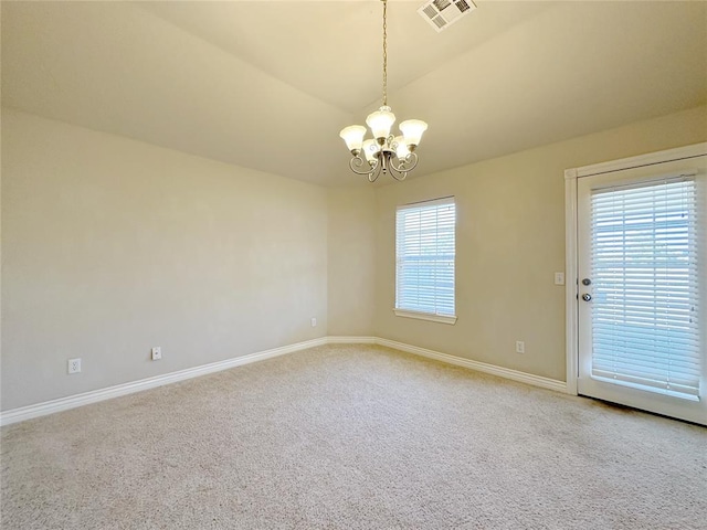 carpeted spare room featuring a chandelier, vaulted ceiling, visible vents, and baseboards