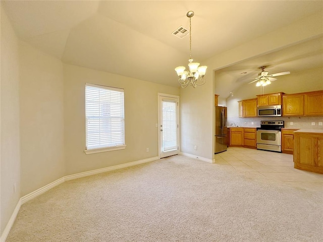 kitchen with light colored carpet, vaulted ceiling, light countertops, appliances with stainless steel finishes, and decorative light fixtures