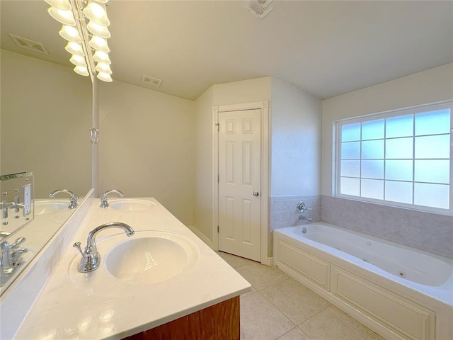 bathroom with a jetted tub, a sink, visible vents, and tile patterned floors