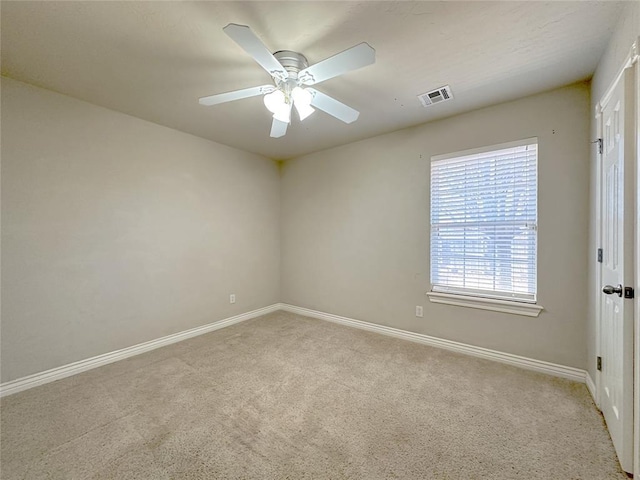 spare room featuring carpet floors, visible vents, baseboards, and a ceiling fan