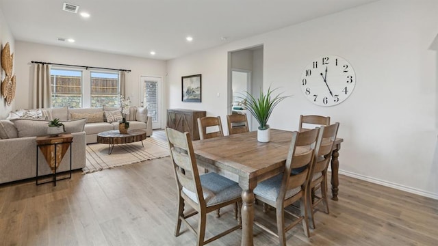 dining room featuring light wood-style floors, baseboards, visible vents, and recessed lighting