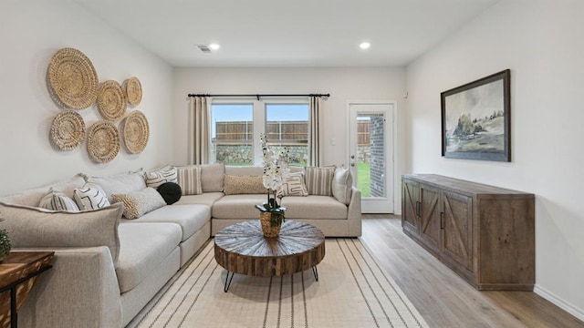 living room featuring recessed lighting, baseboards, visible vents, and light wood finished floors