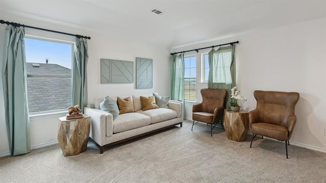 living area with a healthy amount of sunlight, carpet, visible vents, and baseboards