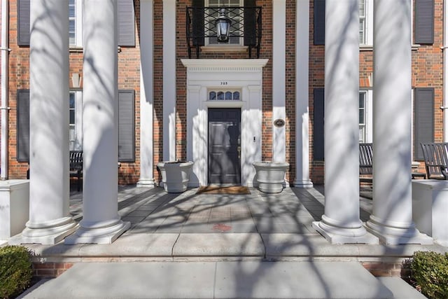 view of exterior entry featuring brick siding