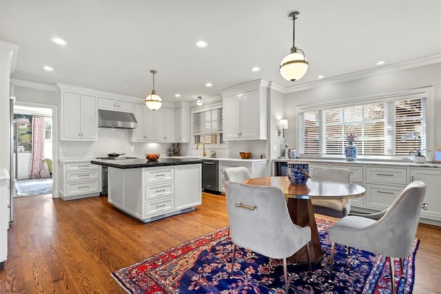 dining room with plenty of natural light, light wood-style flooring, and crown molding