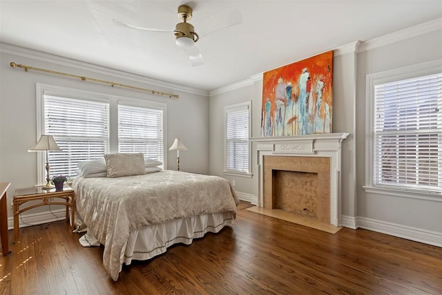 bedroom featuring baseboards, crown molding, a premium fireplace, and wood finished floors