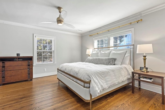 bedroom with baseboards, visible vents, crown molding, and wood finished floors