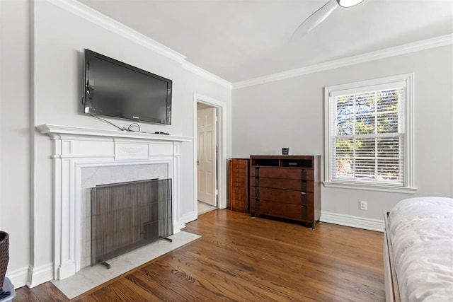 bedroom with crown molding, baseboards, and wood finished floors