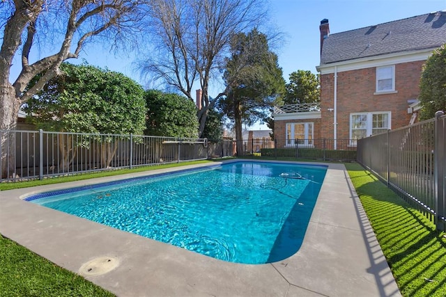 view of swimming pool featuring a fenced in pool, a fenced backyard, and a lawn