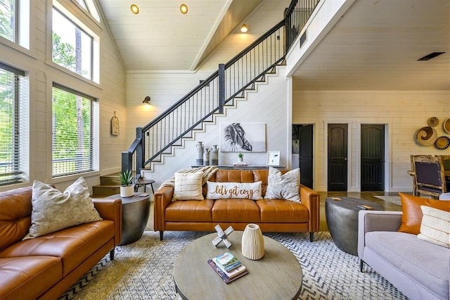 living area with high vaulted ceiling, stairway, wood ceiling, and wooden walls