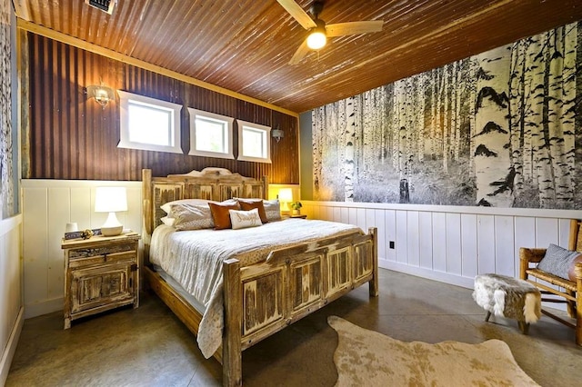 bedroom featuring wooden ceiling, wainscoting, ceiling fan, and finished concrete flooring