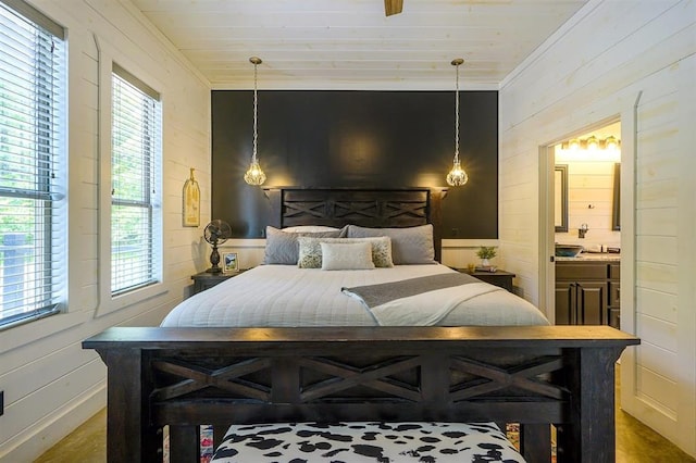 bedroom featuring ensuite bathroom, wood walls, wood ceiling, and crown molding