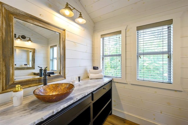 bathroom featuring lofted ceiling, wood walls, wooden ceiling, and vanity