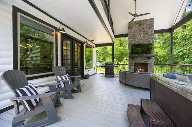 deck featuring an outdoor stone fireplace and grilling area