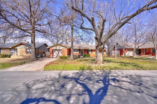 single story home featuring concrete driveway, brick siding, and an attached garage