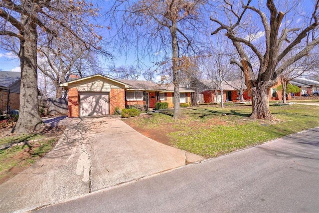 single story home with a front yard, concrete driveway, brick siding, and an attached garage