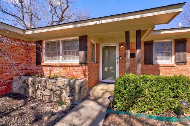 view of exterior entry with brick siding