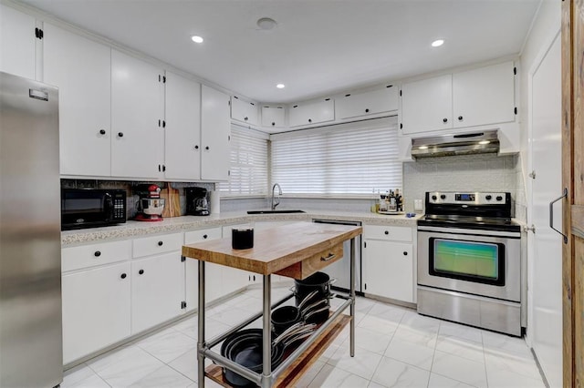 kitchen with range hood, light countertops, decorative backsplash, appliances with stainless steel finishes, and a sink