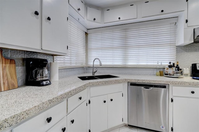 kitchen featuring dishwasher, a sink, and white cabinetry