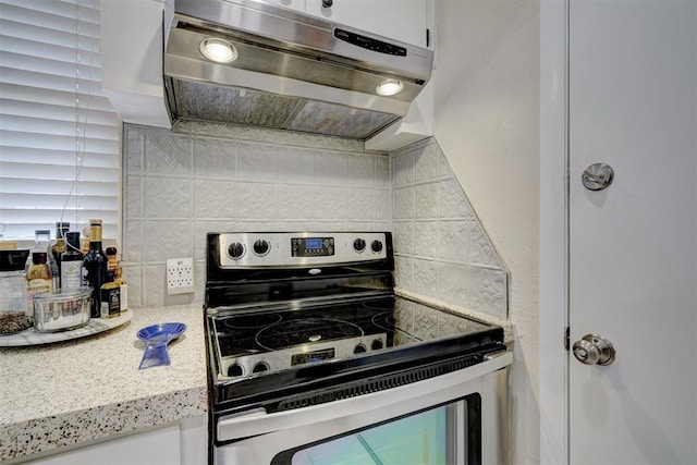 kitchen with range hood, white cabinets, decorative backsplash, and stainless steel electric stove