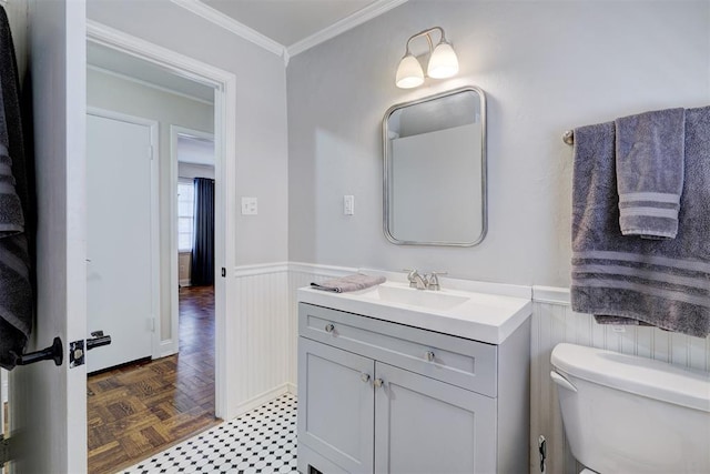 bathroom with toilet, a wainscoted wall, ornamental molding, and vanity