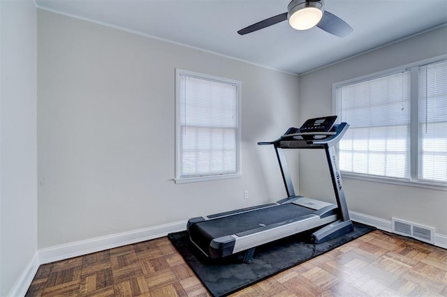 workout room with crown molding, a ceiling fan, visible vents, and baseboards