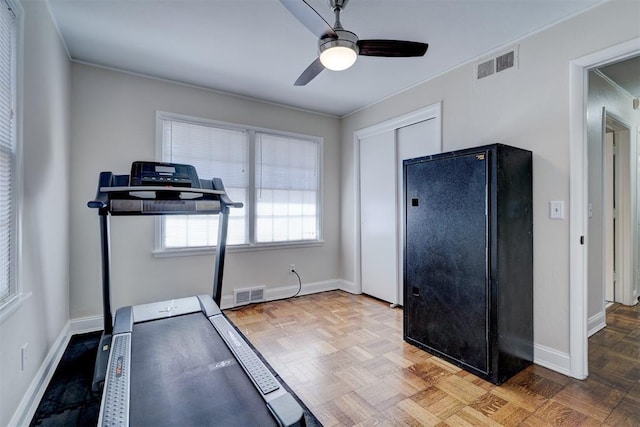 workout area with baseboards, visible vents, and ceiling fan