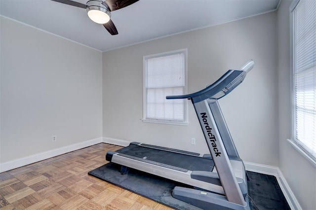 workout room featuring ceiling fan, baseboards, and crown molding