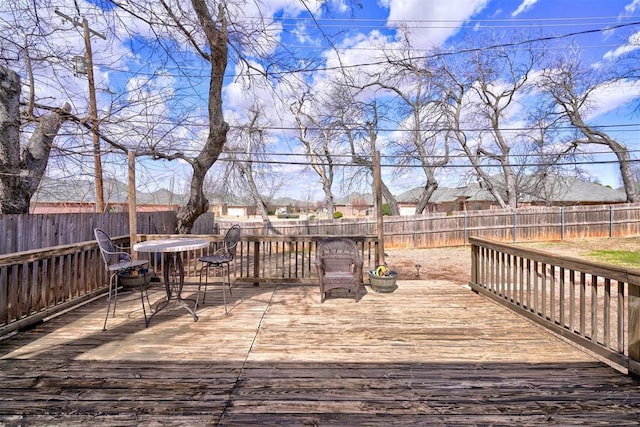 wooden terrace with a fenced backyard