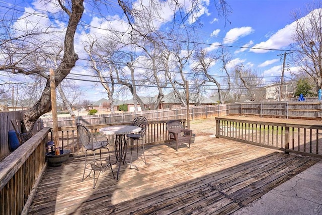 wooden deck with outdoor dining area and a fenced backyard