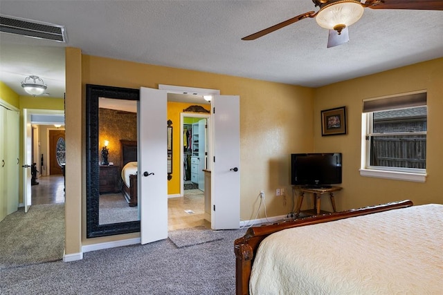 bedroom featuring visible vents, carpet, ceiling fan, and a textured ceiling