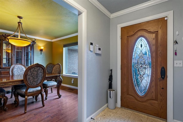 entryway featuring light floors, a textured ceiling, baseboards, and ornamental molding