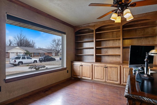 office area with built in shelves, a ceiling fan, a textured ceiling, dark wood-style floors, and baseboards