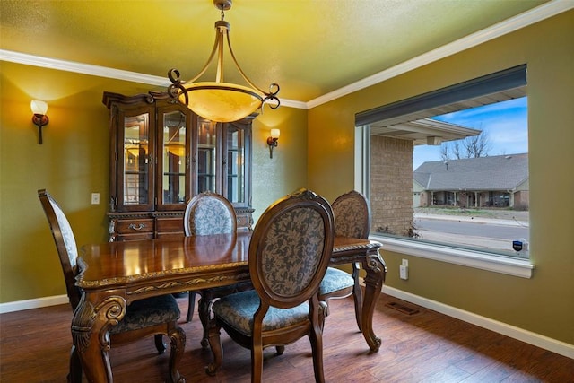 dining area with visible vents, crown molding, baseboards, and wood finished floors