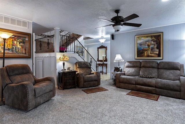 carpeted living area with visible vents, a textured ceiling, stairs, and a ceiling fan