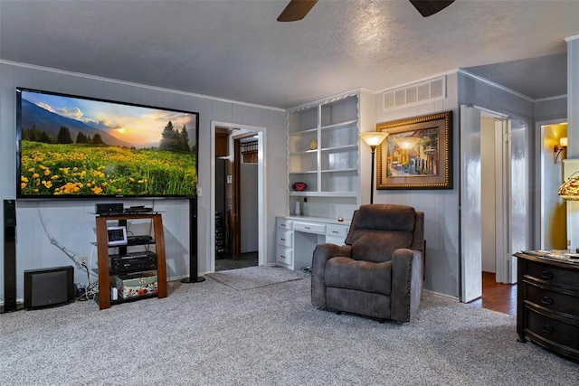 sitting room featuring visible vents, a textured ceiling, crown molding, and carpet