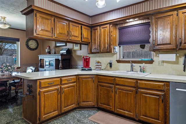 kitchen with a sink, wallpapered walls, light countertops, a peninsula, and stainless steel dishwasher