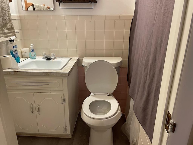 full bath with tile walls, toilet, and vanity