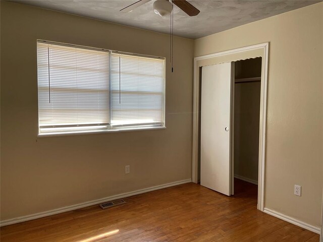 112 N King Ave, Midwest City, OK 73130 - unfurnished bedroom featuring wood finished floors, visible vents, a closet, and baseboards