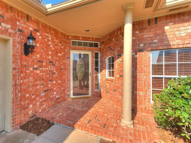 view of exterior entry with brick siding