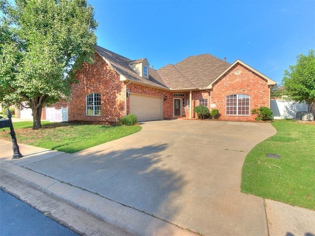 view of front of property featuring a garage, a front lawn, concrete driveway, and brick siding