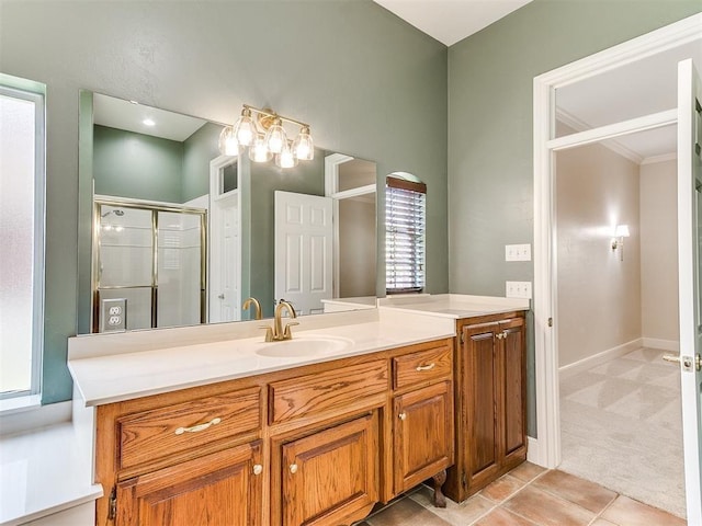 bathroom featuring a stall shower, tile patterned floors, baseboards, and vanity