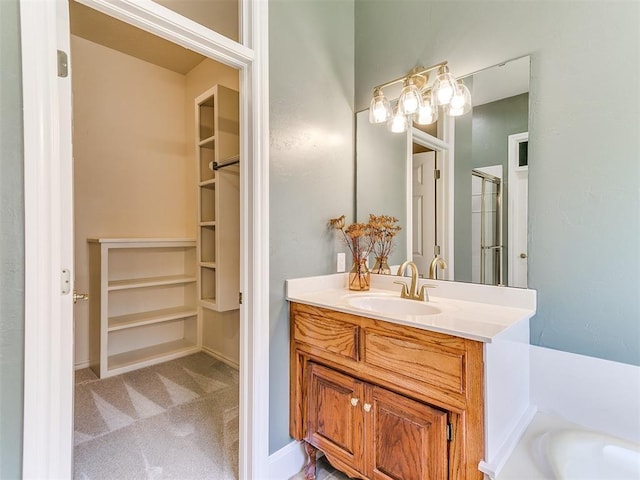 bathroom featuring a washtub, a walk in closet, vanity, and an enclosed shower