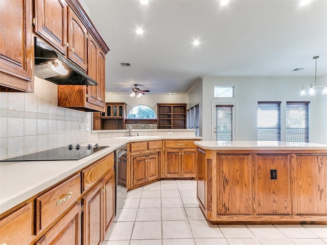 kitchen with light tile patterned floors, black electric stovetop, light countertops, under cabinet range hood, and stainless steel dishwasher