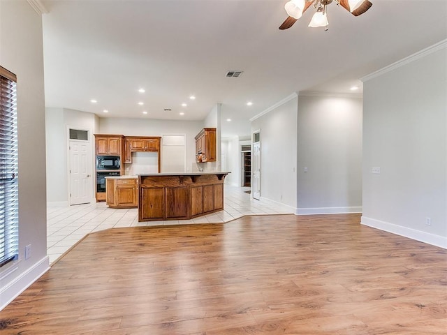 kitchen featuring visible vents, brown cabinets, open floor plan, light countertops, and black appliances