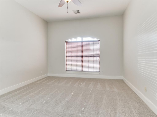 unfurnished room featuring light carpet, baseboards, visible vents, and a ceiling fan