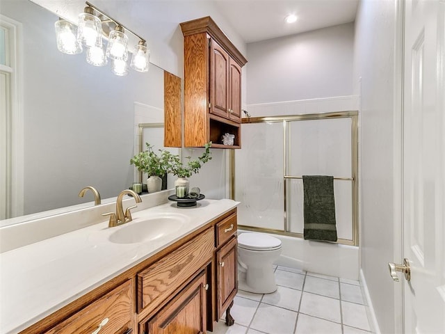 bathroom with bath / shower combo with glass door, vanity, toilet, and tile patterned floors