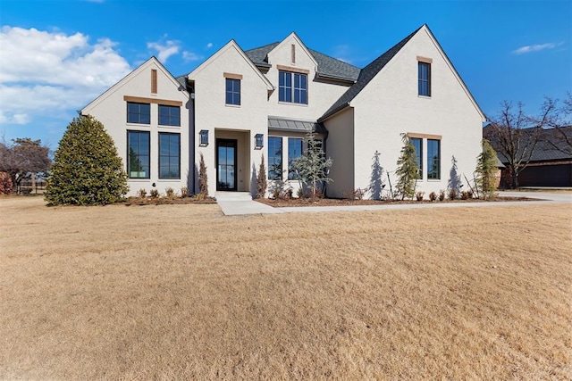 view of front of house with stucco siding and a front yard