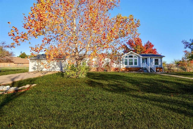 view of front of home featuring entry steps, concrete driveway, and a front lawn