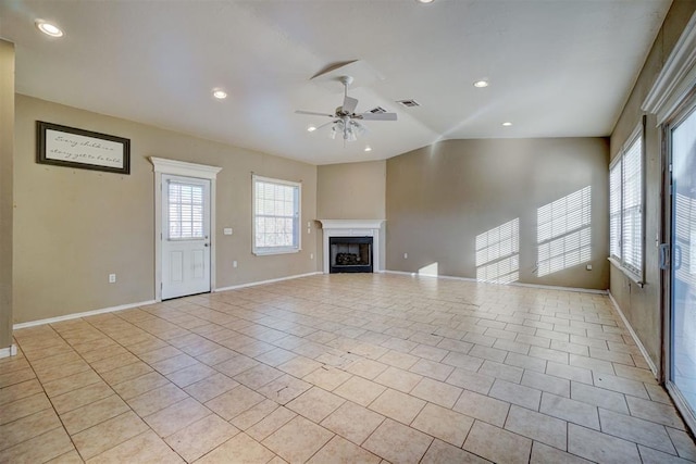 unfurnished living room with a fireplace, light tile patterned floors, visible vents, a ceiling fan, and vaulted ceiling